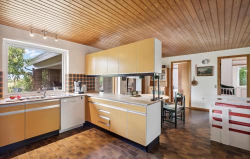 a kitchen with white cabinets and a wooden ceiling at 2 Bedroom Pet Friendly Home In Thisted in Thisted