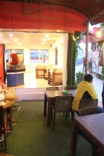 a man sitting at a table in a restaurant at Hotel Kailash Mansarobar Banquet and Restaurant in Kathmandu