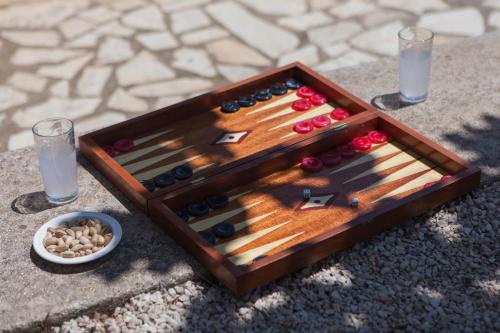 a wooden tray with wine bottles and nuts on a table at Dialiskari Villas in Marathopolis