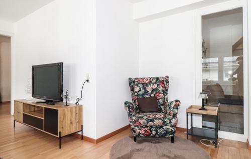 a living room with a chair and a tv at Ferienwohnung In Bludenz in Bludenz