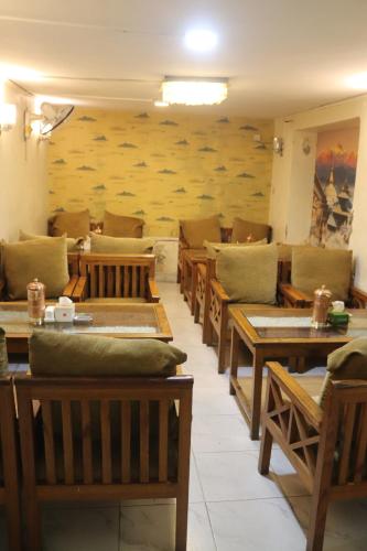 a dining room with wooden tables and benches at Hotel Kailash Mansarobar Banquet and Restaurant in Kathmandu