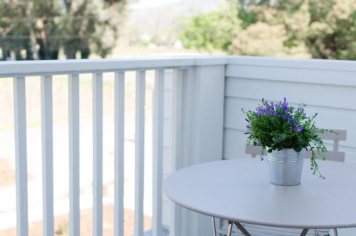a white table with a potted plant on a balcony at The Setting Inn Napa Valley in Napa