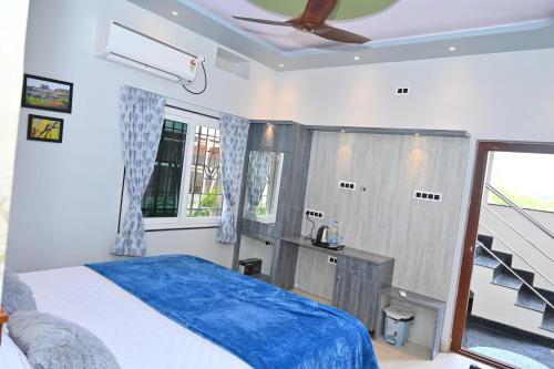a bedroom with a bed and a ceiling fan at Gopi Abode Hampi in Hampi