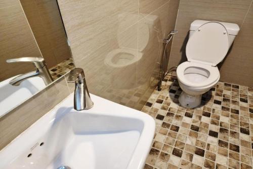 a bathroom with a white sink and a toilet at Station 203 Hotel in Bangkok