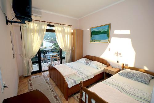 a bedroom with two beds and a balcony at Apartments Radosavovic in Bar