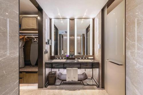 a bathroom with a sink and a large mirror at Golden Eagle Summit Hotel Kunshan in Suzhou