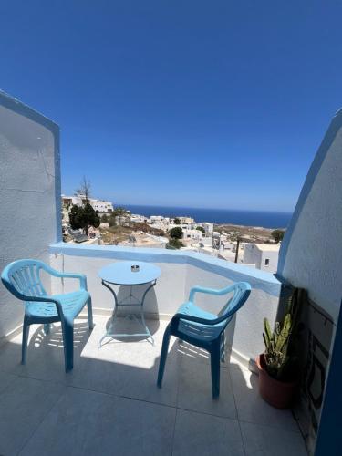 a patio with two chairs and a table with a view at Stella Nomikou Apartments in Firostefani