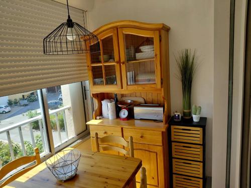 une cuisine avec une armoire en bois et une table dans l'établissement Appart Cap D’agde, au Cap d'Agde