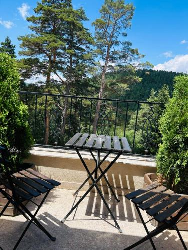 a picnic table and two benches on a balcony at Villa Ema in Panichishte