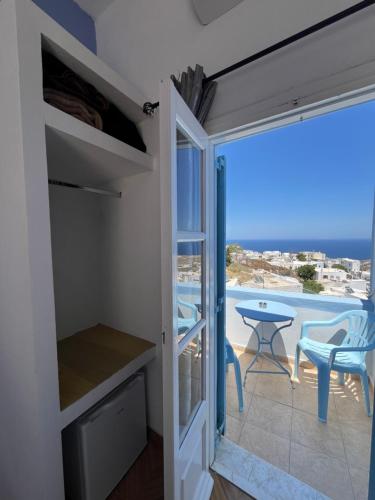 a room with a balcony with a view of the ocean at Stella Nomikou Apartments in Firostefani