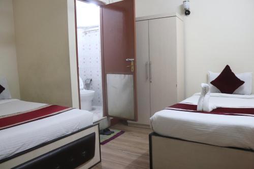 a hotel room with two beds and a television at Hotel Kailash Mansarobar Banquet and Restaurant in Kathmandu