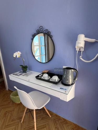 a table with a mirror and a chair in a room at Stella Nomikou Apartments in Firostefani