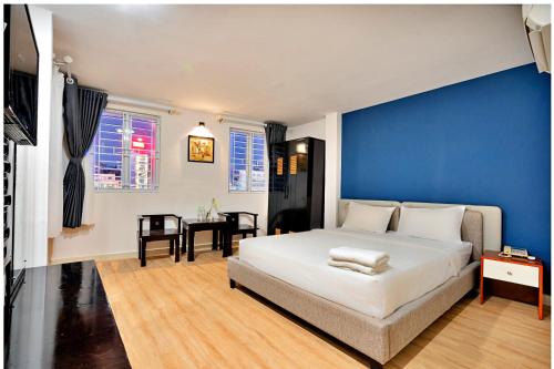a bedroom with a large bed with a blue wall at S79 Residences SEN in Ho Chi Minh City