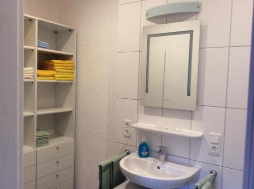 a white bathroom with a sink and a mirror at Fewo Blütenreich in Traben-Trarbach