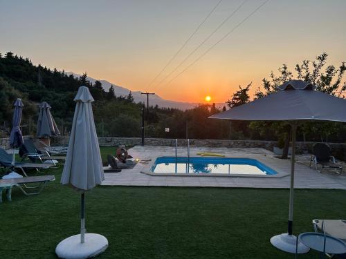 a patio with an umbrella and a swimming pool at Old stone villa in Apokoronas Villa Nostalgia Kreta in Fílippos