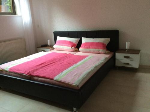 a bedroom with a bed with two pink pillows at Fewo Blütenreich in Traben-Trarbach