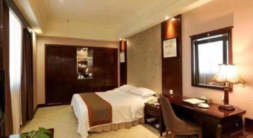 a hotel room with a bed and a desk at Chaozhou Hotel in Chaozhou