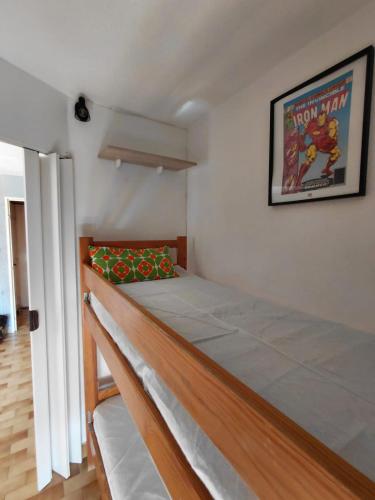 - un lit dans une chambre avec une photo sur le mur dans l'établissement Appart Cap D’agde, au Cap d'Agde