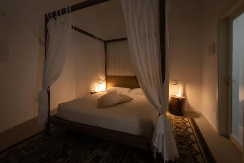 a bedroom with a canopy bed with two lamps at Dimora Del Dragone in Vieste