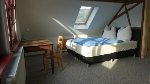 a bedroom with a bed and a desk and a window at Café Landart im Thüringer Finistère in Plaue