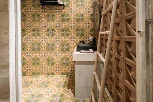 a kitchen with a counter and a wall with a pattern at Tropical Traditional Indonesian Wooden Cottage - Beji Mas, Ubud in Ubud