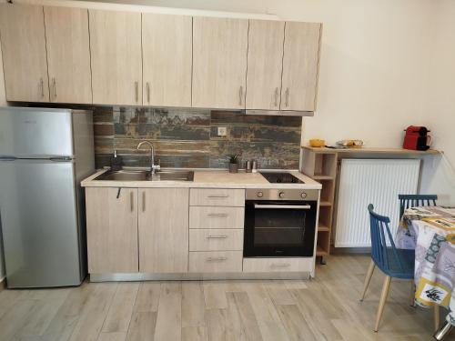 a kitchen with wooden cabinets and a stainless steel refrigerator at Patsis Appartment in Ýpsos