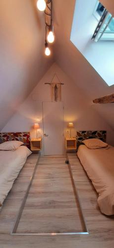- une chambre mansardée avec 2 lits et une porte dans l'établissement Les Gîtes de l'Orta, à Saint-Jean-dʼEyraud