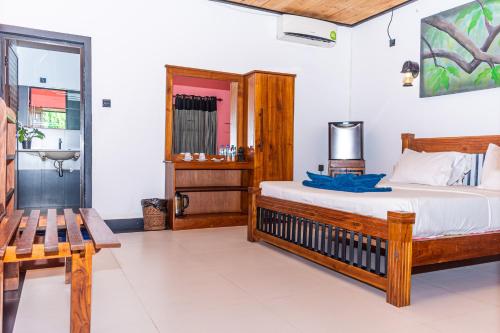 a bedroom with a bed and a bench and a sink at Eco Hotel Black & White - Anuradhapura in Mihintale