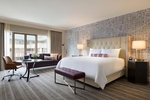 a hotel room with a bed and a desk at The Fairmont Washington DC in Washington, D.C.