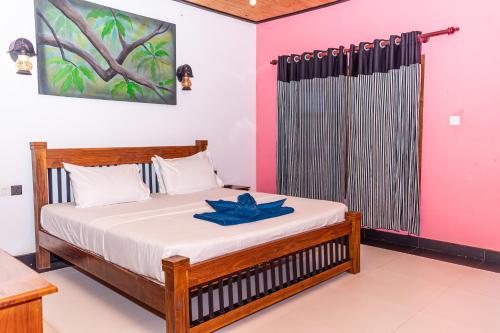 a bedroom with a bed with a blue ribbon on it at Eco Hotel Black & White - Anuradhapura in Mihintale