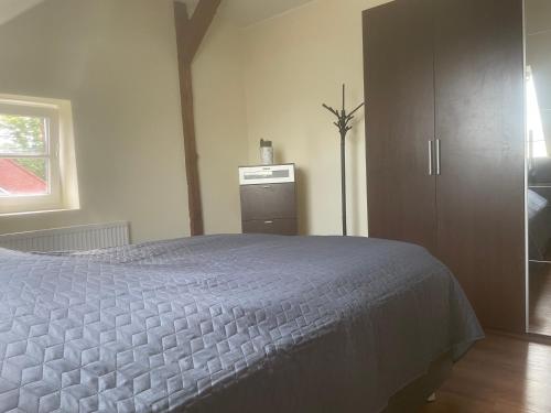 a bedroom with a large bed and a cabinet at Apartament an der Landgestüt in Warendorf