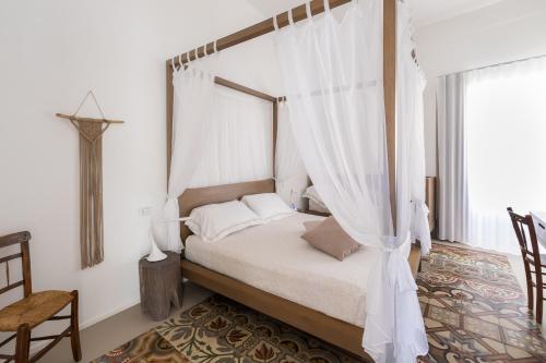 a bedroom with a canopy bed with white curtains at Dimora Del Dragone in Vieste