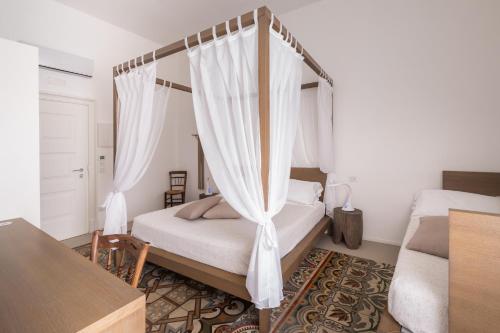 a bedroom with a canopy bed with white curtains at Dimora Del Dragone in Vieste