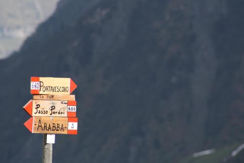 a pile of signs on top of a pole at La Baita in Livinallongo del Col di Lana