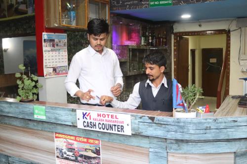 two men standing at a counter in a restaurant at Hotel Kailash Mansarobar Banquet and Restaurant in Kathmandu
