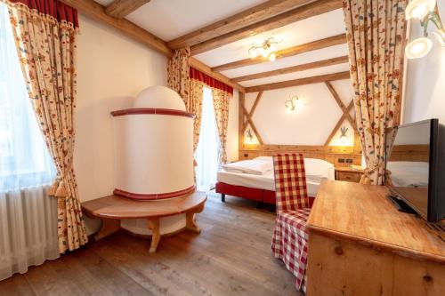 a bedroom with a bed and a tv in a room at Hotel Laurin in Canazei