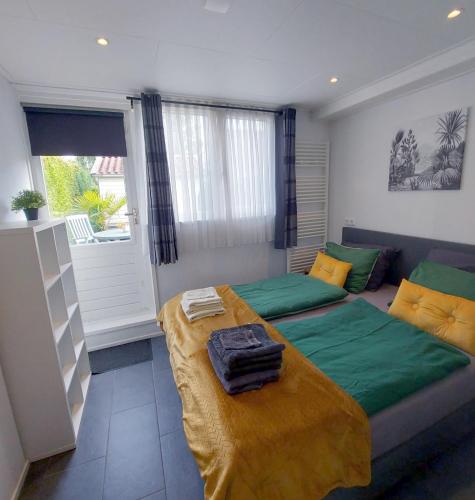 a bedroom with a bed and a couch and a window at B&B Margriet in Lemmer