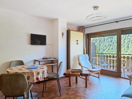 un salon avec une table et des chaises et un balcon dans l'établissement Champs Fleuris CFS7 COSY & VIEW 3 Pers, à Châtel