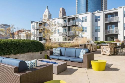 a patio with blue couches and tables and buildings at CozySuites - Current at the Banks in Cincinnati