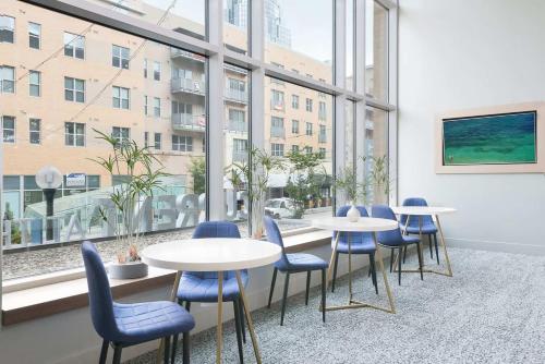 a room with tables and chairs and a large window at CozySuites - Current at the Banks in Cincinnati