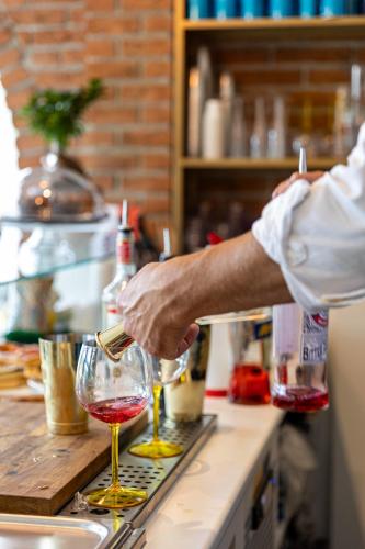 a man pouring two glasses of wine on a counter at Villa Vitali - Bellagio in Bellagio