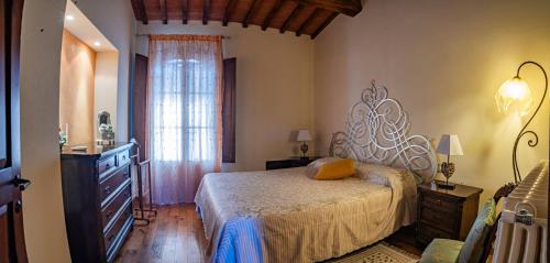 a bedroom with a bed and a dresser and a window at Appartamento L'Allodola in Montespertoli