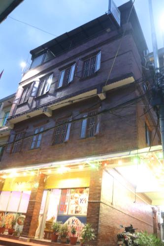 a tall brick building with windows on a street at Hotel Kailash Mansarobar Banquet and Restaurant in Kathmandu