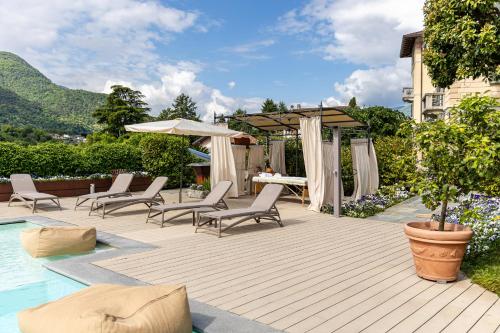 a patio with chairs and an umbrella next to a pool at Villa Vitali - Bellagio in Bellagio