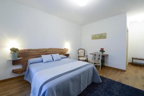 a bedroom with a bed and a chair and a table at Agriturismo Rivella in Barbaresco
