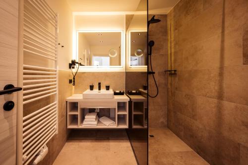 a bathroom with a sink and a mirror at Hotel Villa Flora in Velden am Wörthersee