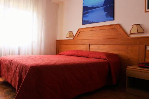 a bedroom with a bed and a dresser at Hotel Paganella in Molveno