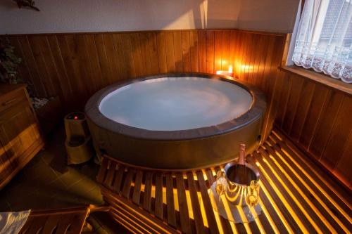 a large bath tub in a wooden room with a bench at Holiday home in Trebelno - Dolenjska & Bela krajina Unter- & Weißkrain 26032 in Trebelno