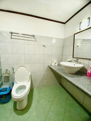 a bathroom with a toilet and a sink at TipTop Hotel, Resto and Delishop in Panglao