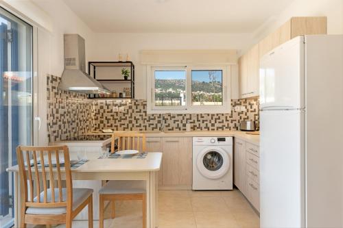 a kitchen with a table and a white refrigerator at Sandoa Residence - Lualaba & Tenke in Minia